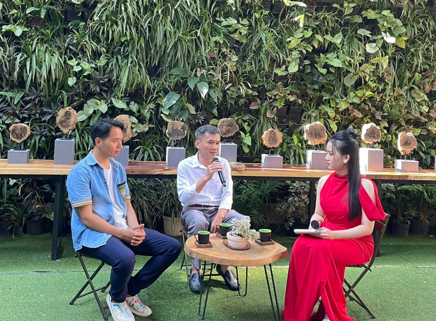 Họa sĩ Nông Hoàng Chiến (giữa) chia sẻ về những tấm ảnh được phóng tác trên gỗ cà phê