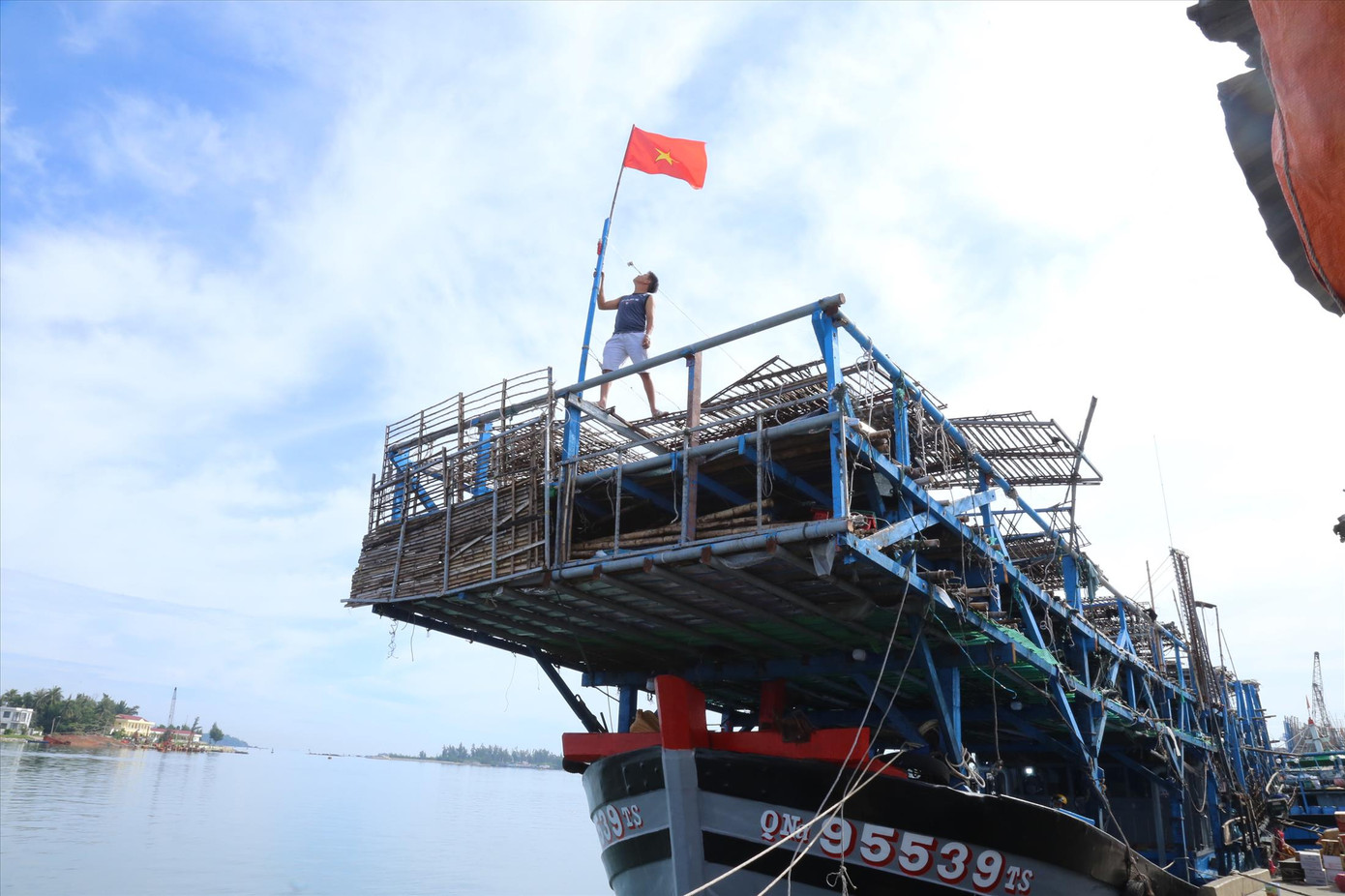 Ngư dân thay mới cờ Tổ quốc sẵn sàng vươn khơi. Ảnh: Hoài Văn