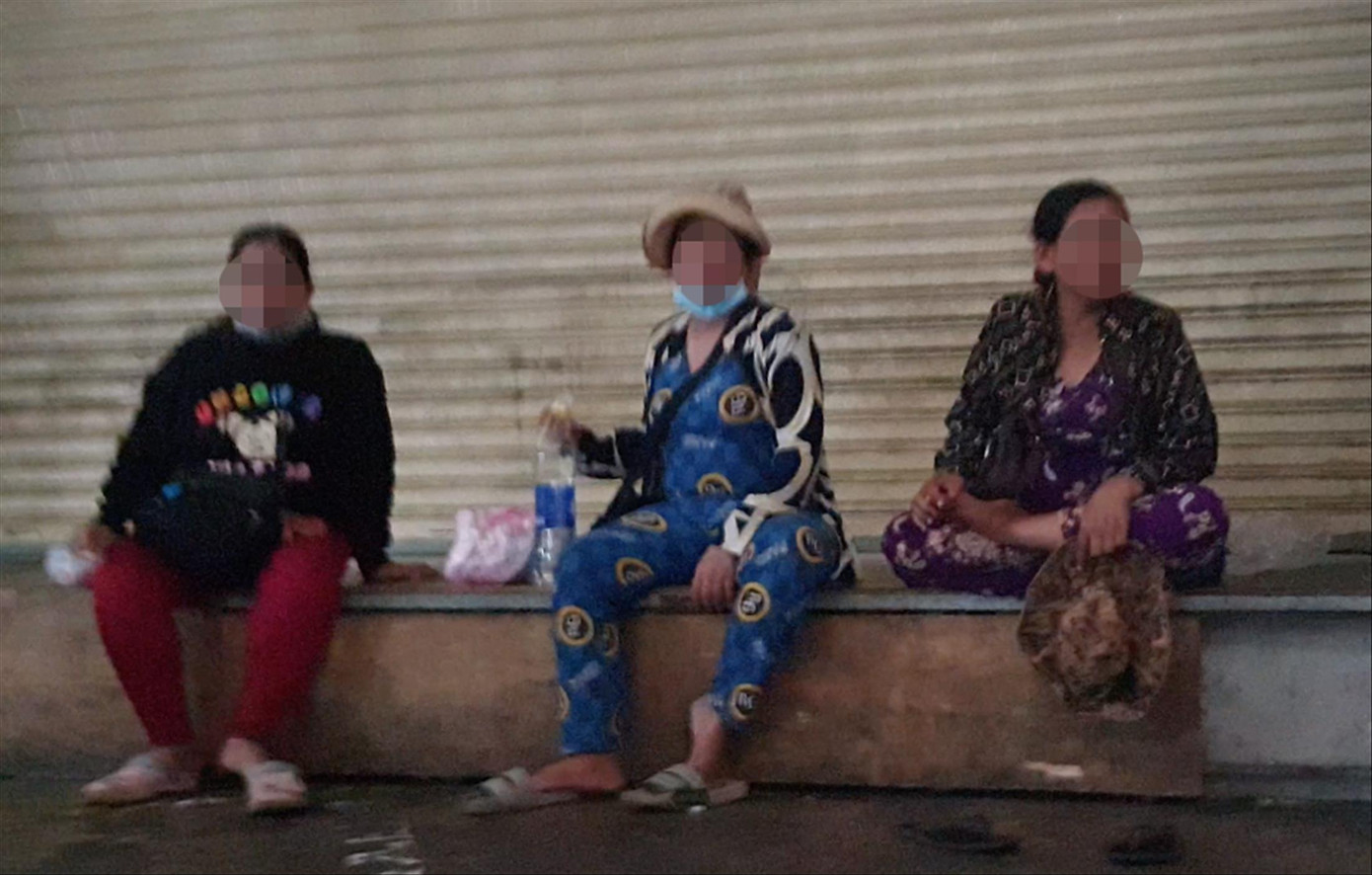 Nhóm người phụ nữ chăn dắt trẻ em ăn xin ngồi “tám chuyện” trong nhà lồng chợ. Ảnh: Thuận Nhàn. Nhóm người phụ nữ chăn dắt trẻ em ăn xin ngồi “tám chuyện” trong nhà lồng chợ. Ảnh: Thuận Nhàn.