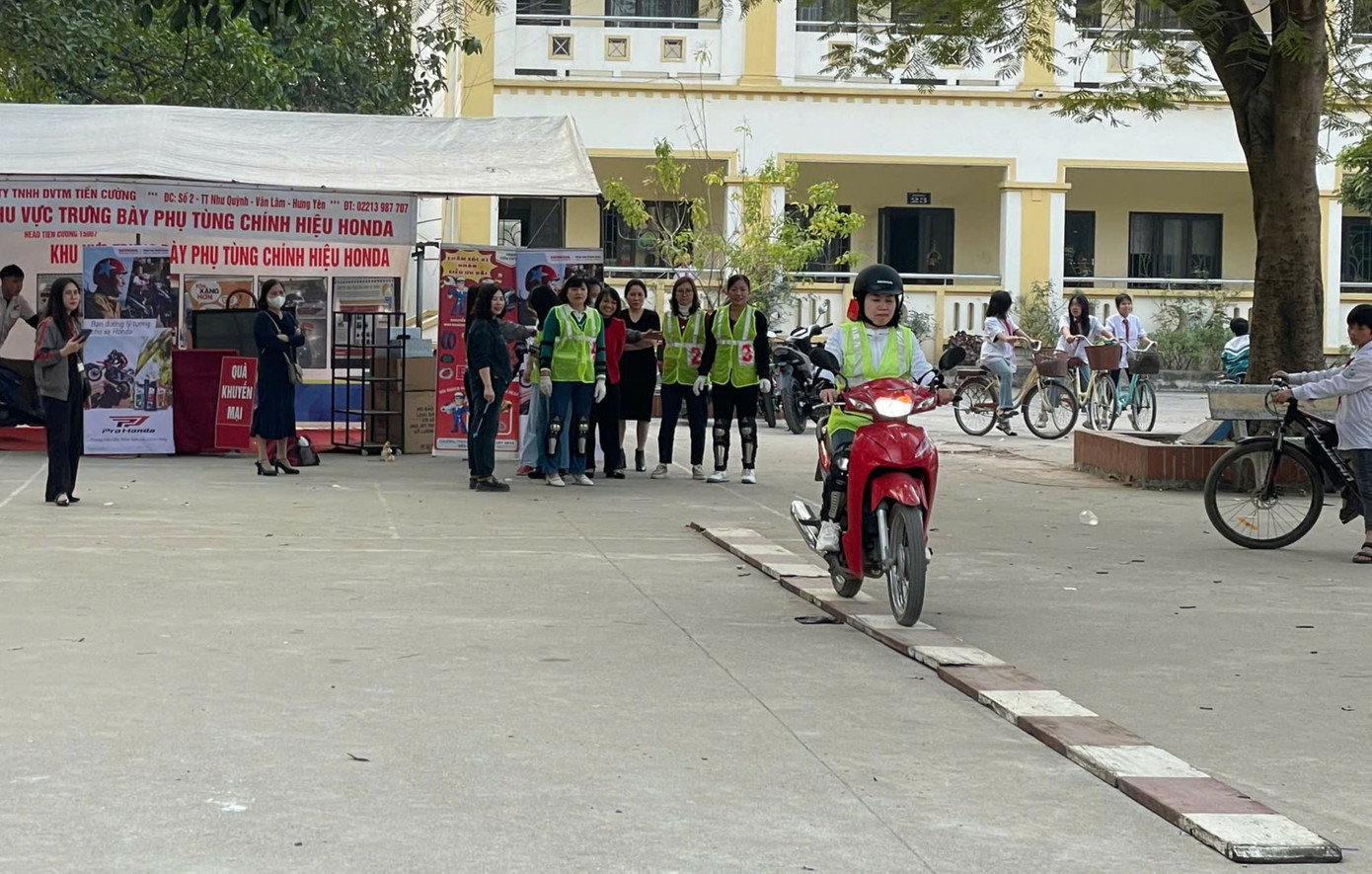 Các thầy cô giáo và một số phụ huynh học sinh thử tay lái của mình trong phần thử thách lái xe thăng bằng và đi xe zích zắc theo cọc tiêu.