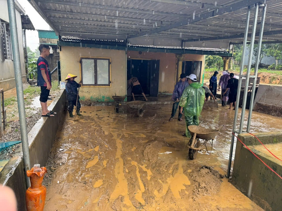 Người dân dọn dẹp bùn đất sau lũ. Ảnh: Văn Lình