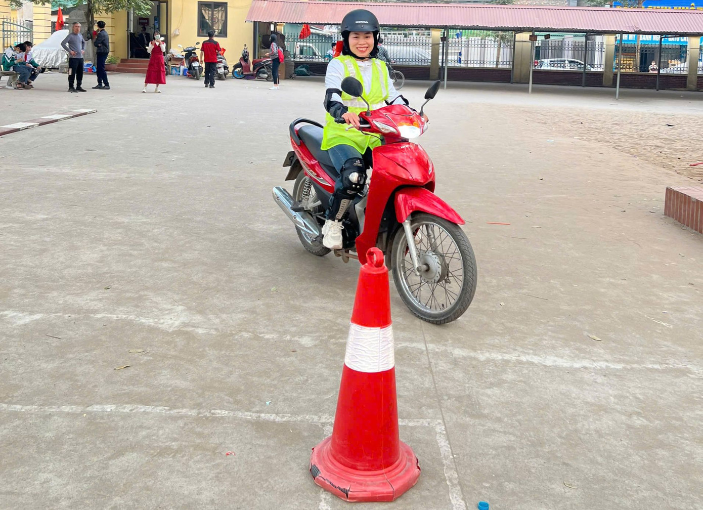 Các thầy cô giáo và một số phụ huynh học sinh thử tay lái của mình trong phần thử thách lái xe thăng bằng và đi xe zích zắc theo cọc tiêu.