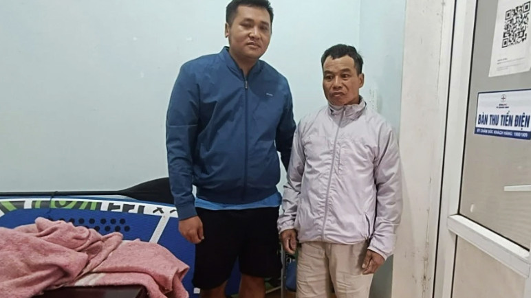 Ông Trương Văn Duy (bên phải) được cán bộ Điện lực Lệ Thủy cứu sống sau hơn 12 giờ đồng hồ đu trên cột điện giữa mênh mông nước lũ.