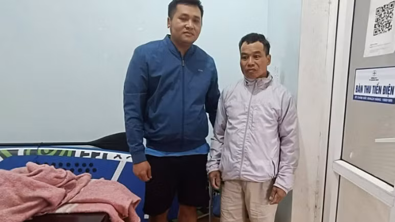 Ông Trương Văn Duy (bên phải) được cán bộ Điện lực Lệ Thủy cứu sống sau hơn 12 giờ đồng hồ đu trên cột điện giữa mênh mông nước lũ.