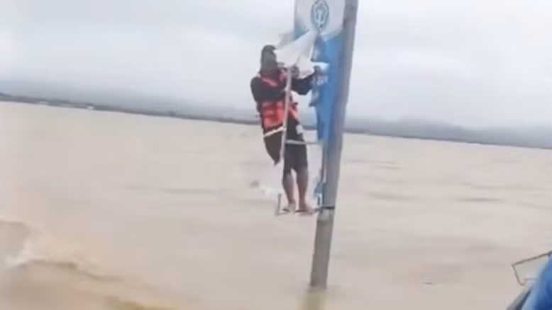 Ông Trương Văn Duy đu bám vào cột điện xuyên đêm giữa lũ đến sáng nay thì được cứu.
