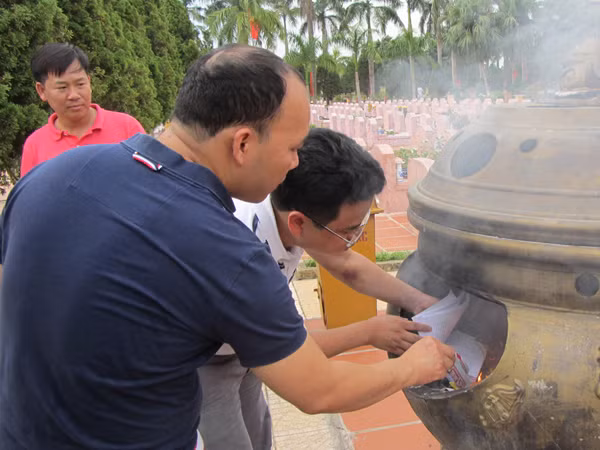 TS Nguyễn Huy Hoàng (đầu bạc) cùng anh em CLB May Thăng Long viếng mộ chị Đặng Thùy Trâm