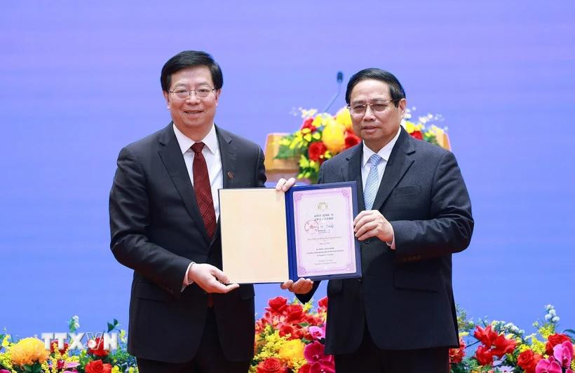 GS.TS. Khưu Dũng tặng Thủ tướng Phạm Minh Chính danh hiệu "Giáo sư danh dự Đại học Thanh Hoa". Ảnh: TTXVN.