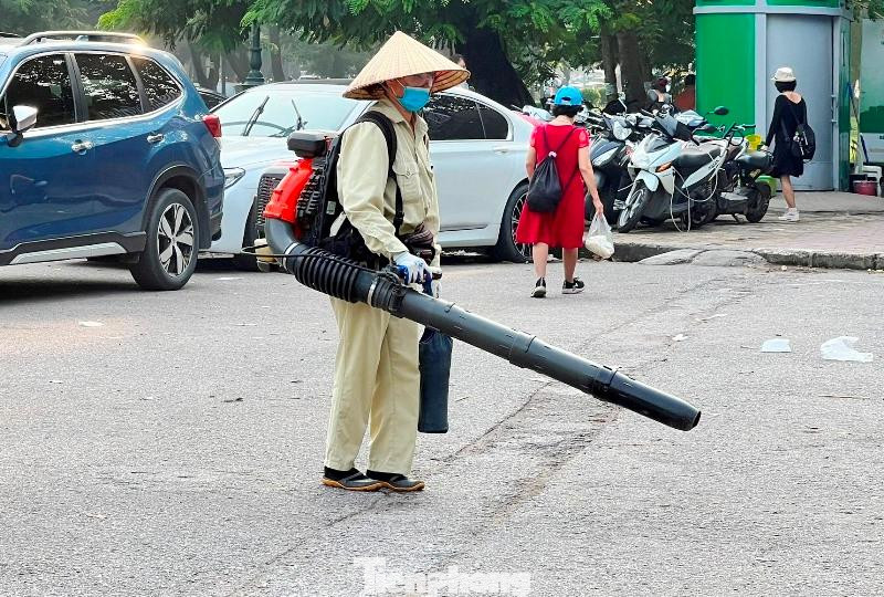 Từ việc dùng chổi và đẩy xe đi theo để thu gom rác, hiện trên nhiều tuyến phố Hà Nội lại xuất hiện những công nhân vệ sinh "cõng" máy nén khí và ống thổi rất cồng kềnh.
