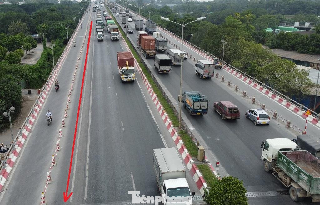 Ngoài ra, đường dẫn xuống cầu Thanh Trì ở hai đầu đã được thu hẹp dải phân cách để mở rộng làn ô tô, nhưng nhiều vạch liền vẫn chưa được xóa bỏ (mũi tên đỏ), dẫn đến ô tô đi theo làn đường cũ, không dám đi sang làn đường vừa được mở rộng.