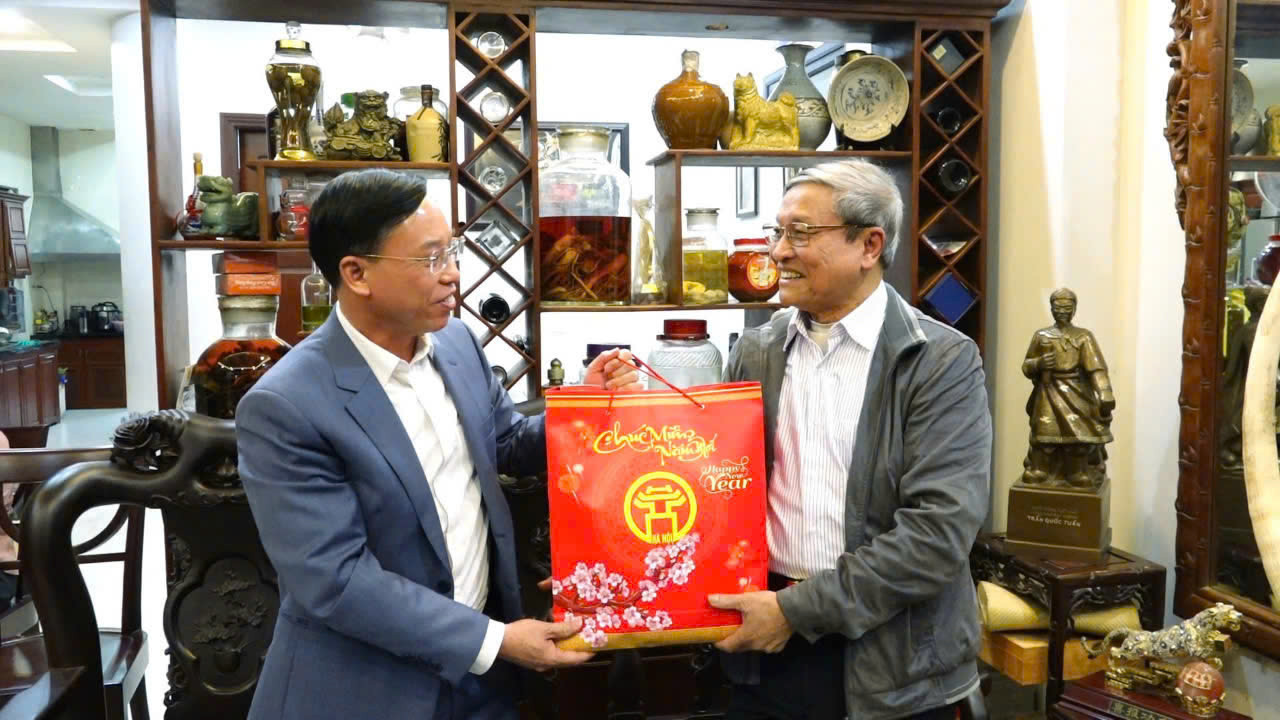 Phó Bí thư Quận uỷ - Chủ tịch UBND quận Long Biên Nguyễn Mạnh Hà tặng quà cho cán bộ hưu trí. Ảnh: PV.