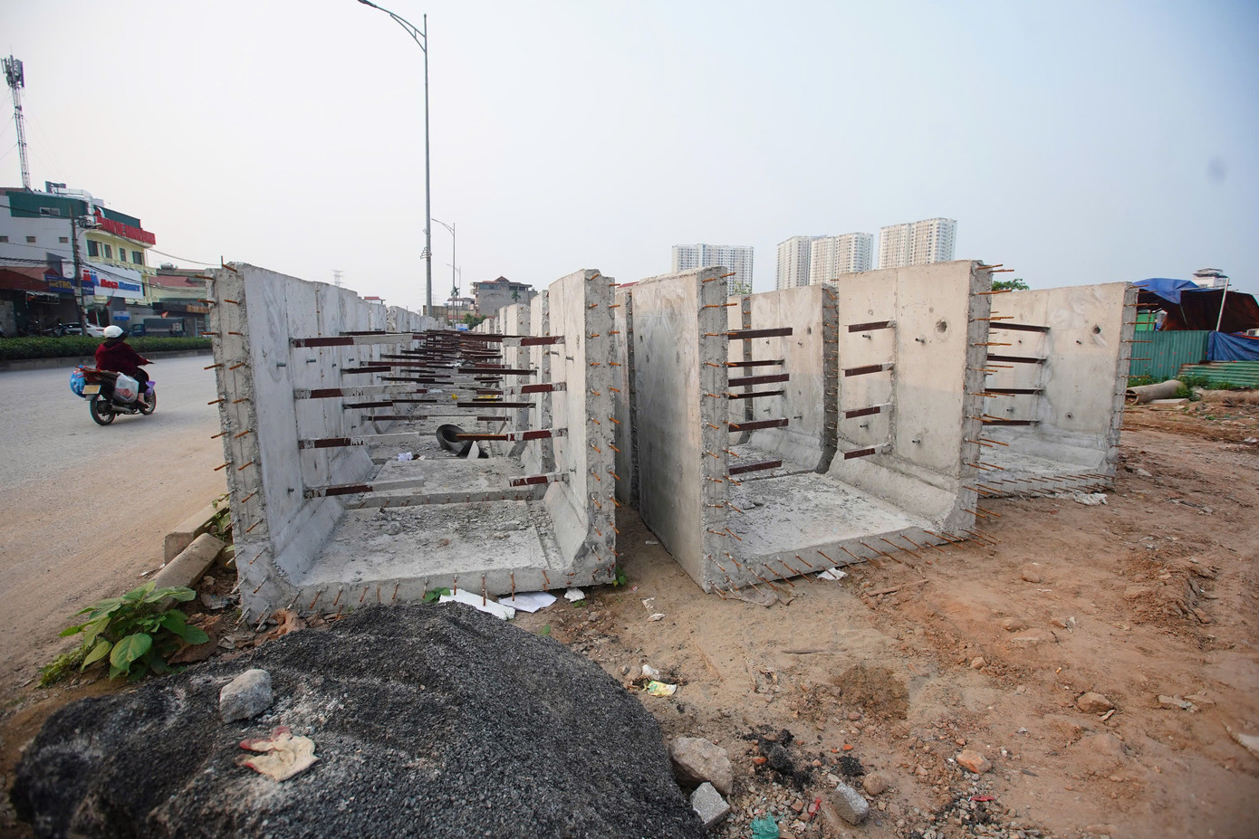 Các cấu kiện bê tông phục vụ thi công dự án đường Tam Trinh tập kết ven đường, không có cảnh báo.