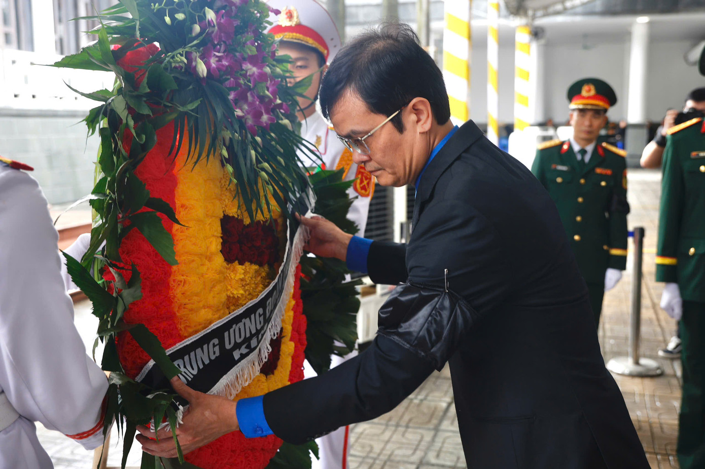 Bí thư thứ nhất Trung ương Đoàn TNCS Hồ Chí Minh Bùi Quang Huy chỉnh trang vòng hoa của đoàn trước khi vào viếng nguyên Chủ tịch nước Trần Đức Lương.