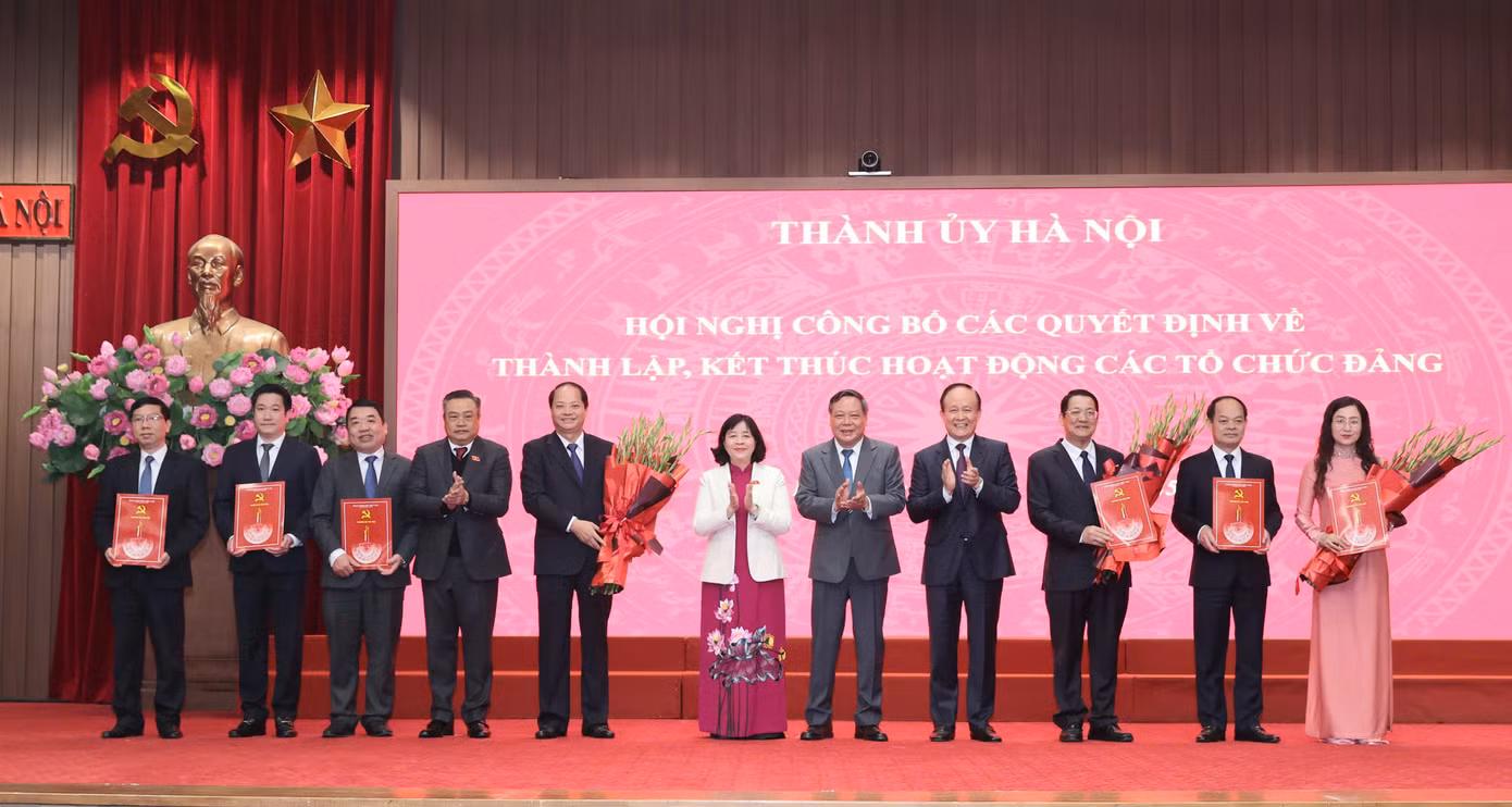 Bí thư Thành ủy Hà Nội Bùi Thị Minh Hoài và lãnh đạo HĐND, UBND thành phố Hà Nội trao quyết định, tặng hoa chúc mừng Ban Tuyên giáo và Dân vận Thành ủy Hà Nội. Ảnh: Viết Thành.