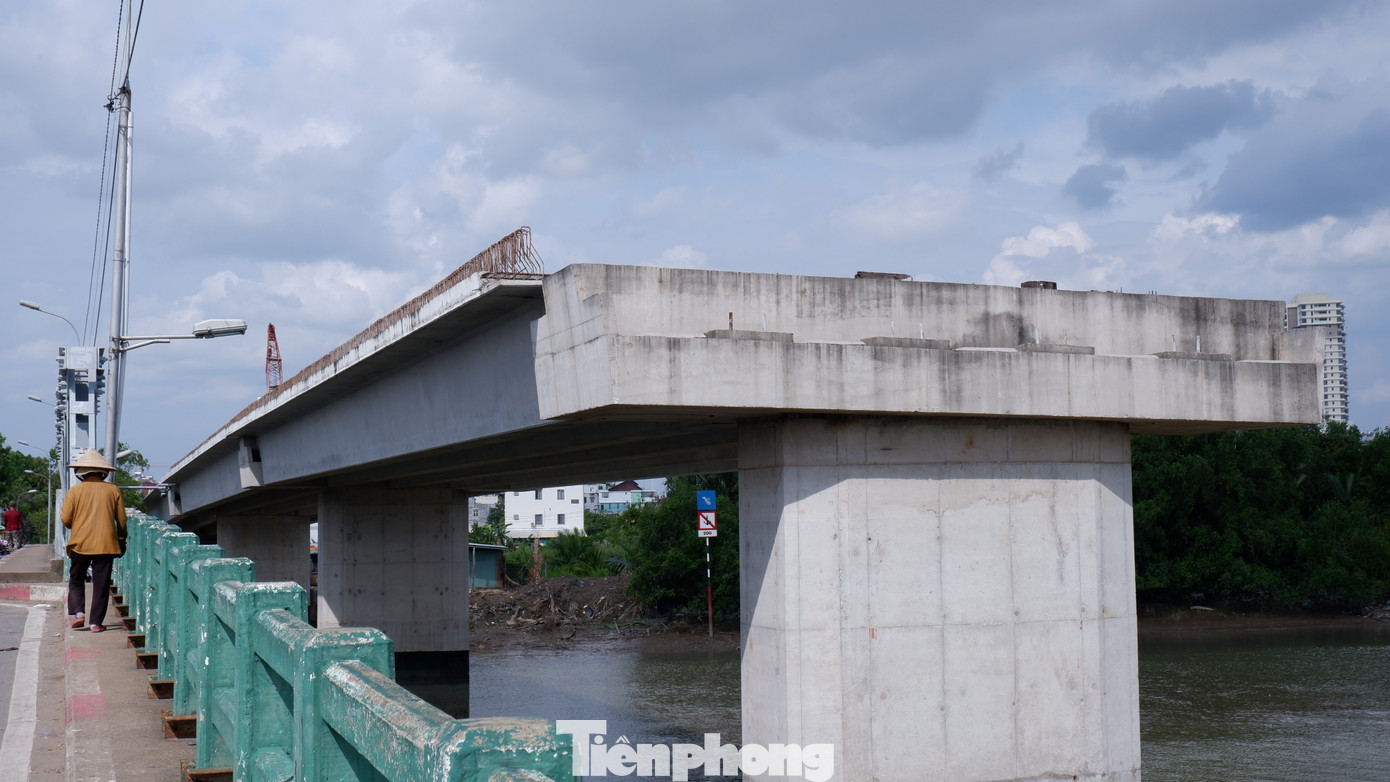 Dự án xây dựng cầu Phước Long mới (bên phải) bắc qua rạch Phú Xuân (nối quận 7 và huyện Nhà Bè, TPHCM) được thực hiện từ năm 2020 nhằm thay thế cầu cũ. Tuy nhiên, khi vừa hoàn thành một số trụ cầu, công trình phải tạm dừng thi công vì vướng mặt bằng.