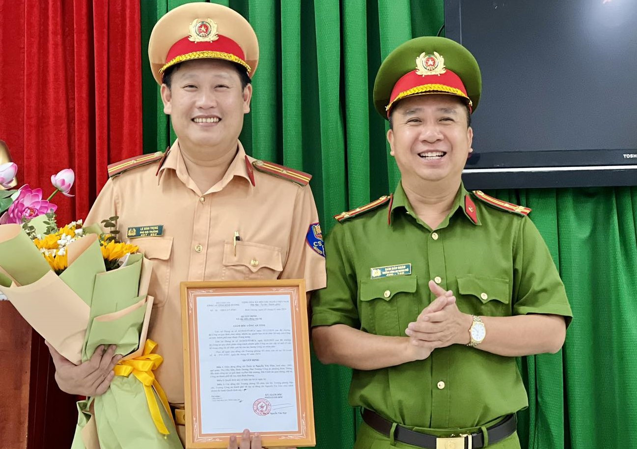 Thượng tá Đàm Bảo Quân, Trưởng Công an TP.Dĩ An (bìa phải) trao quyết định bổ nhiệm Thiếu tá Lê Bình Trọng giữ chức vụ Đội trưởng Đội Cảnh sát Giao thông - trật tự. Thượng tá Đàm Bảo Quân, Trưởng Công an TP.Dĩ An (bìa phải) trao quyết định bổ nhiệm Thiếu tá Lê Bình Trọng giữ chức vụ Đội trưởng Đội Cảnh sát Giao thông - trật tự.