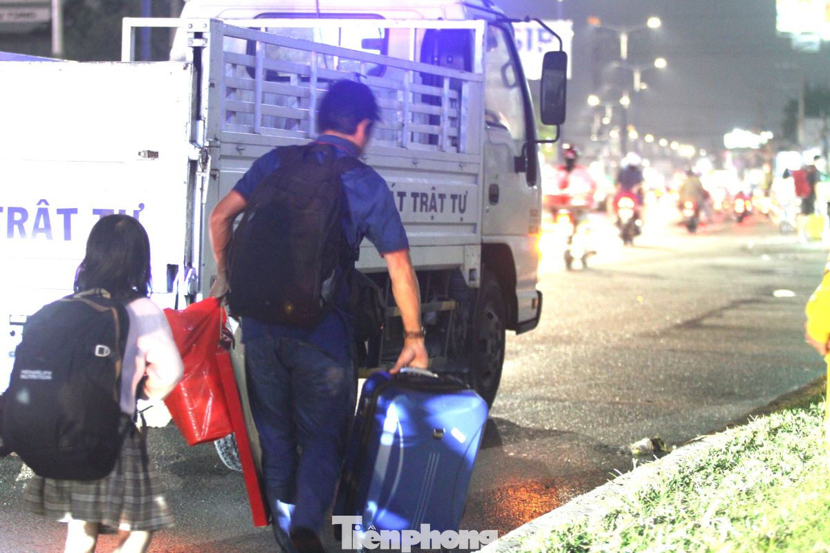 Người dân được cảnh sát hướng dẫn đi tới điểm đón cố định trên tuyến quốc lộ 13.