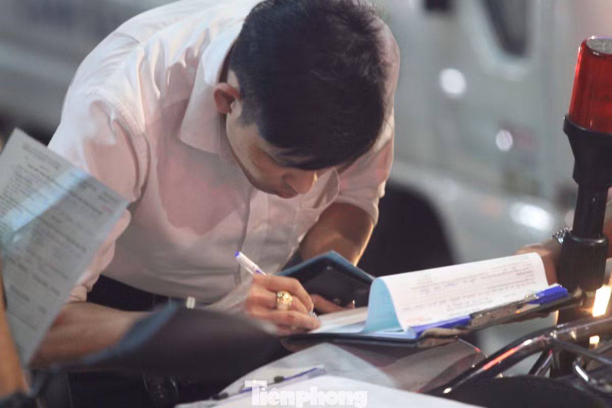 Tài xế ký biên bản vi phạm hành chính với lỗi đậu xe trên vỉa hè. Tài xế ký biên bản vi phạm hành chính với lỗi đậu xe trên vỉa hè.
