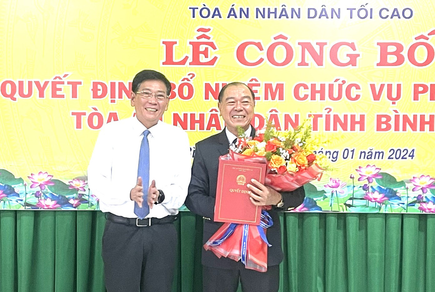 Phó chủ tịch Thường trực UBND tỉnh Bình Dương Mai Hùng Dũng (bìa trái) tặng hoa chúc mừng ông Lê Hoàng Vương.