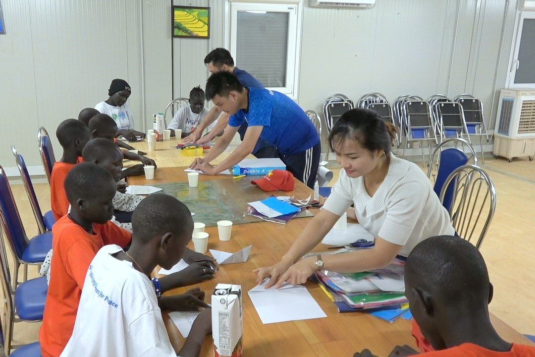 Cán bộ, nhân viên Đội Công binh số 3 hướng dẫn các em nhỏ làm đồ chơi từ những vật liệu tái chế.