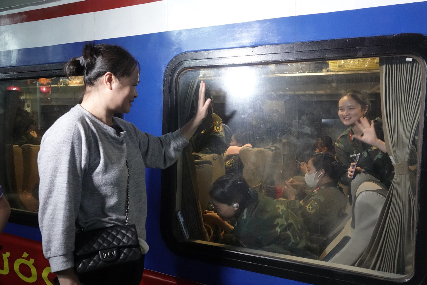 Các bóng hồng áo lính và hậu phương vẫy chào trước khi tàu chuyển bánh.