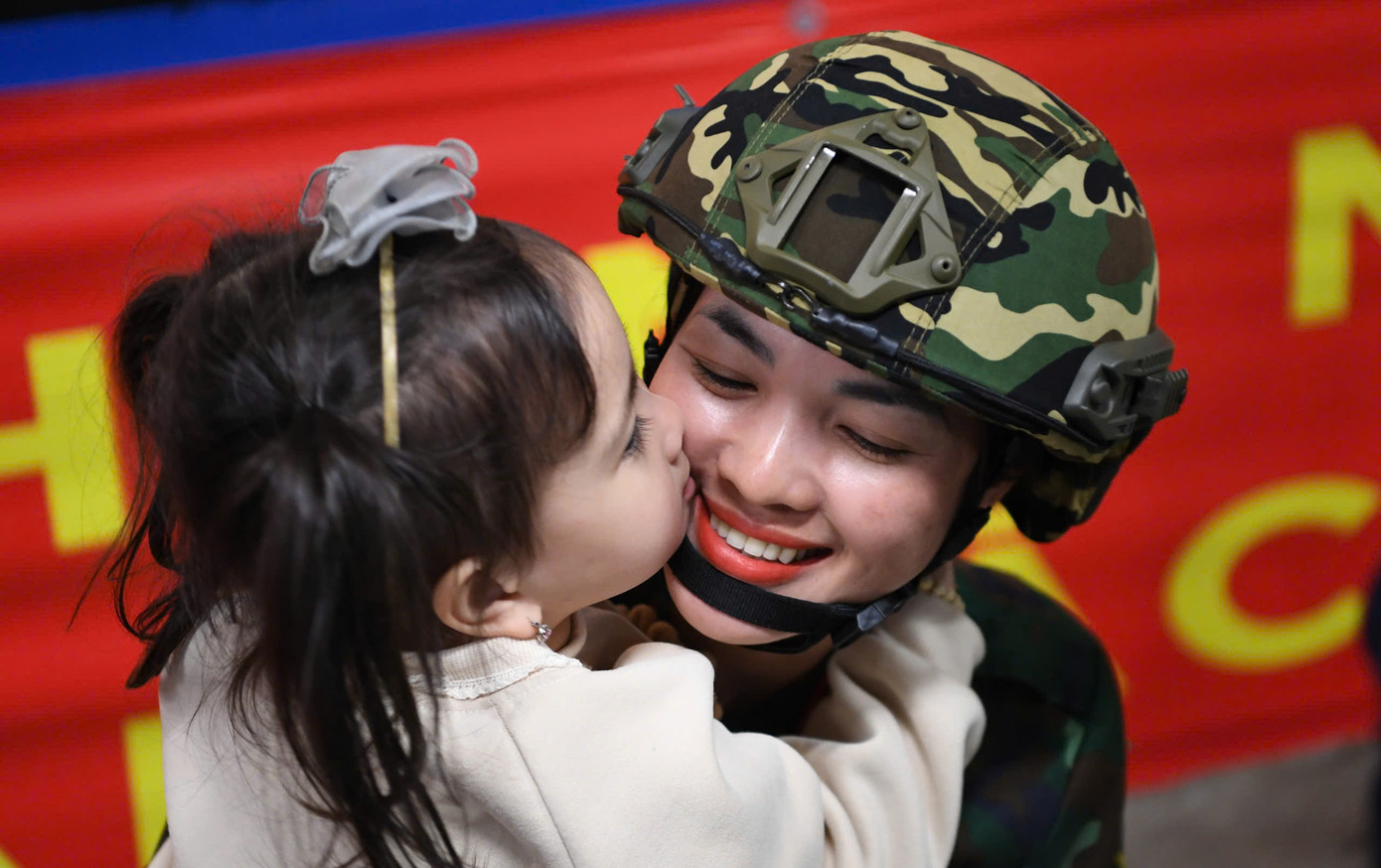 Nữ quân nhân thuộc Khối nữ sĩ quan Thông tin và con gái trao nụ hôn tạm biệt.