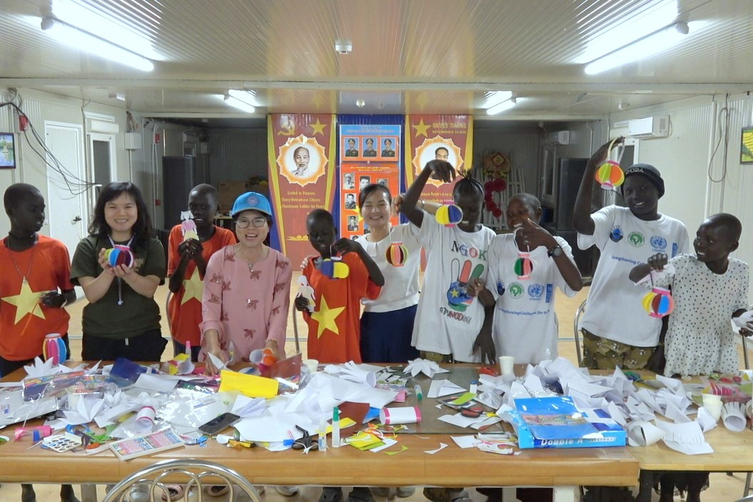 Cán bộ, nhân viên Đội Công binh số 3 hướng dẫn các em nhỏ làm đồ chơi từ những vật liệu tái chế.