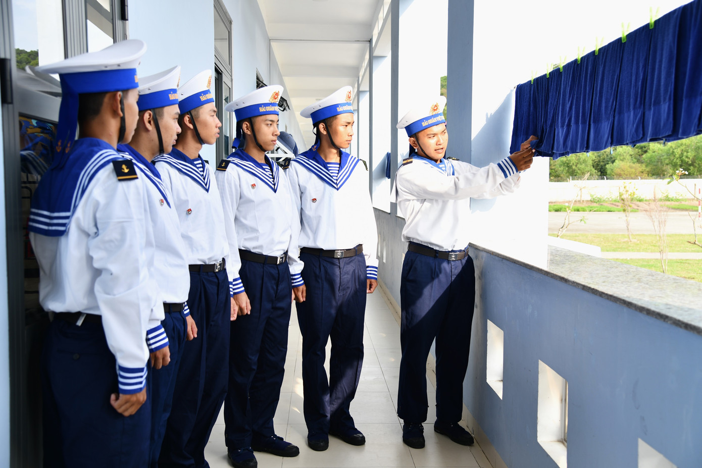 Tiểu đội trưởng hướng dẫn chiến sĩ mới cách phơi khăn mặt.