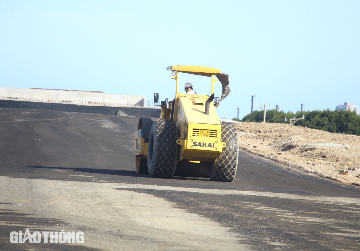 Tương tự, anh Mai Văn Duân cũng đang làm ngày, làm đêm để tăng sản lượng công việc đối với những hạng mục quan trọng (Trong ảnh, chiếc xe lu đang lu lèn dằn chặt nền đường ở cầu Cây Khế 2).