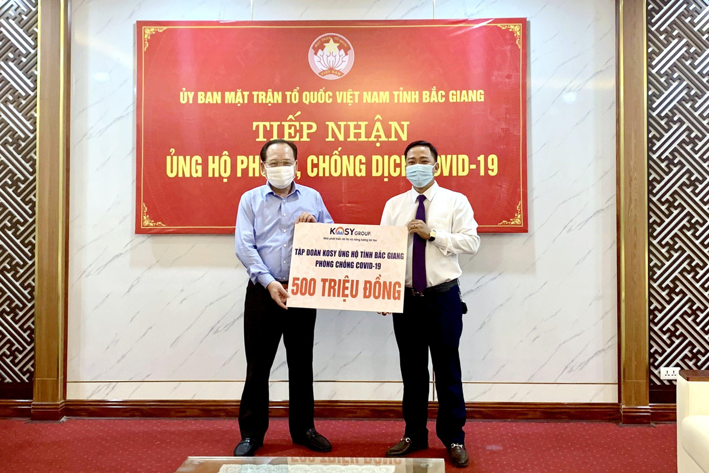 Ông Trần Công Thắng – Chủ tịch Ủy ban Mặt trận Tổ quốc tỉnh Bắc Giang (bên trái) tiếp nhận ủng hộ từ đại diện Tập đoàn Kosy.