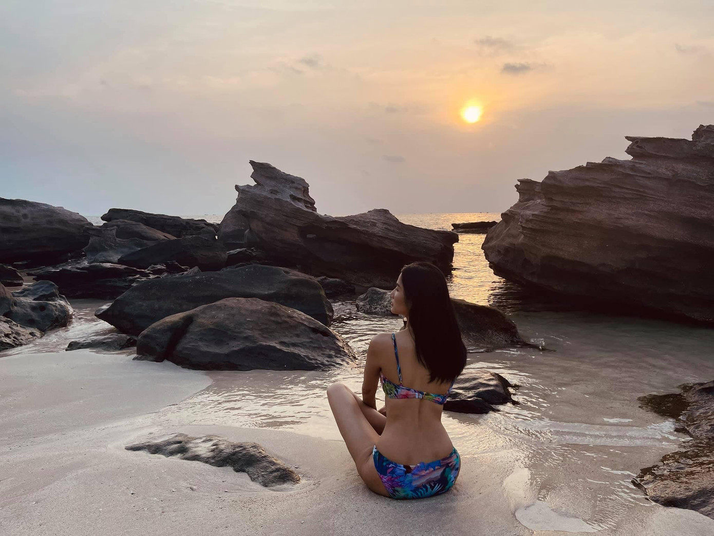 Á hậu Hoàng Thùy khoe lưng trần quyến rũ và vóc dáng mình hạc xương mai trên biển khi diện bikini họa tiết nhiệt đới.