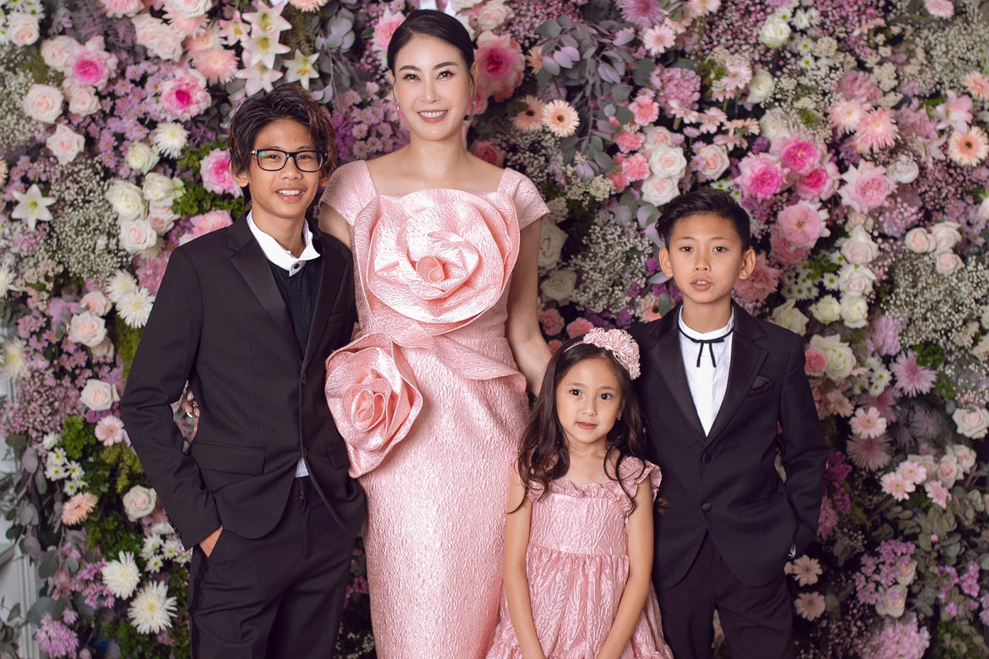Hoa hậu Hà Kiều Anh dự tiệc cùng con gái và 2 con trai. Chị diện đầm có chi tiết hoa hồng to bản, trong khi đó bé Vivian diện đầm xoè nữ tính, điệu đà. Các cậu bé đều diện vest đen lịch lãm.