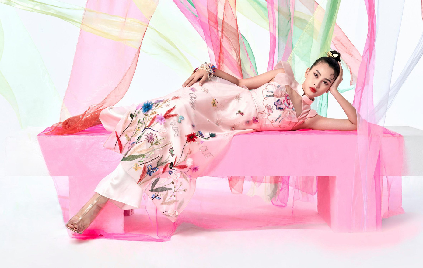 Áo dài tông màu hồng được đính kết hoa cỏ cầu kỳ dọc thân áo mang lại cho nàng hậu xứ Quảng vẻ đẹp ngọt ngào mà không kém phần ma mị.