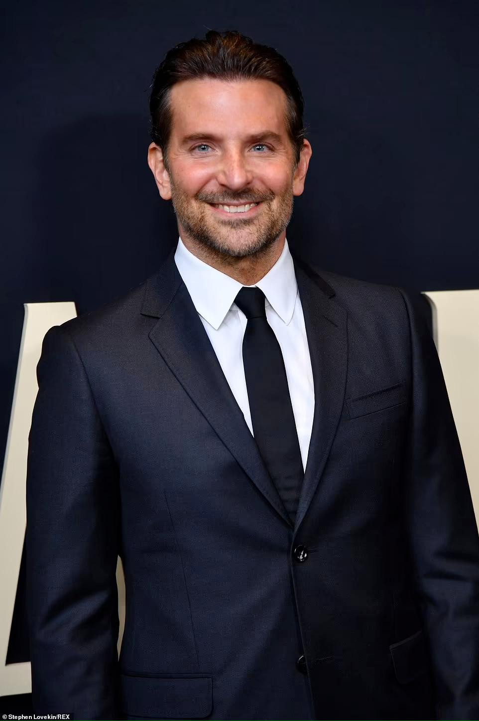 Trong khi đó, tài tử Bradley Cooper bảnh bao, nam tính với Âu phục cổ điển. &quot;Nightmare Alley&quot; là phiên bản làm lại của tác phẩm kinh điển năm 1947, dựa trên tiểu thuyết tội phạm cùng tên của William Lindsay Gresham. Trong phim, Cooper vào vai Stanton Carlisle, một nhà tâm thần học có tài thao túng người khác bằng lời nói, khiến người ta tin rằng hắn có khả năng đọc được suy nghĩ.