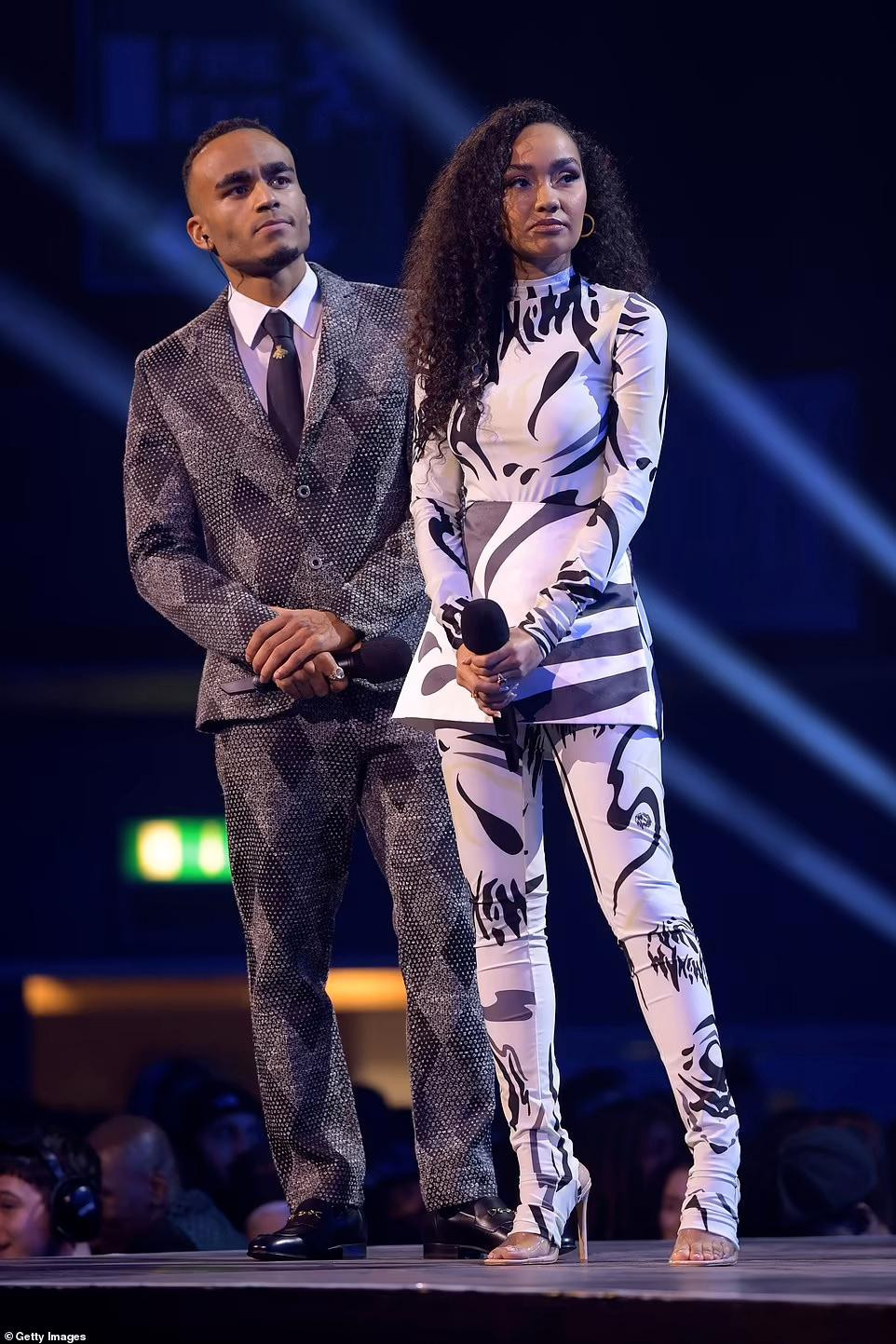 Sau đó, cô kín đáo bất ngờ với bộ quần áo trắng họa tiết đen.