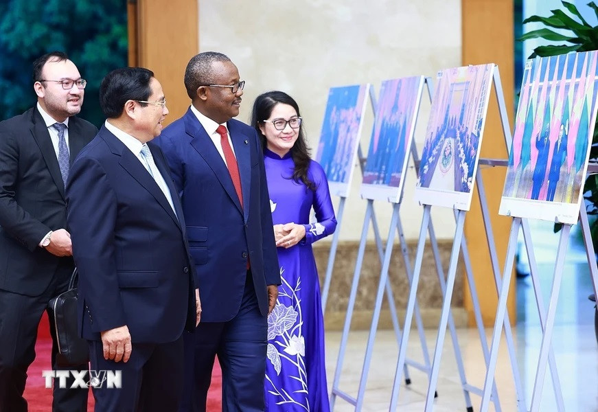 Thủ tướng Phạm Minh Chính và Tổng thống Cộng hòa Guinea-Bissau Umaro Sissoco Embaló xem trưng bày ảnh về quan hệ hợp tác giữa hai nước do TTXVN thực hiện. (Ảnh: Dương Giang/TTXVN)