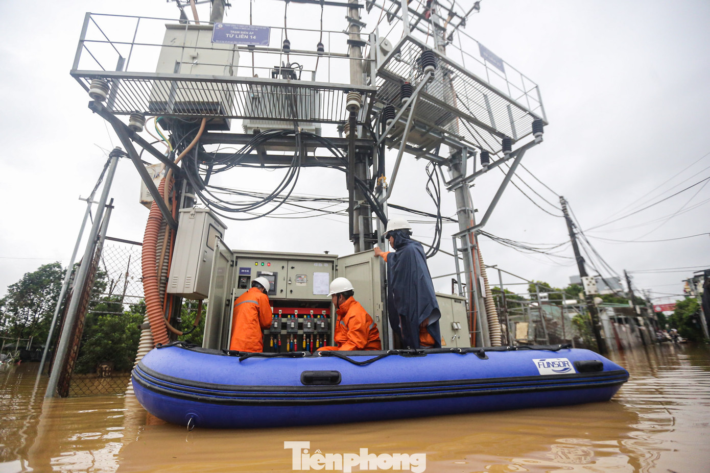 Công nhân điện kiểm tra trạm biến áp giữa lòng nước lũ tại vườn quất Tứ Liên.