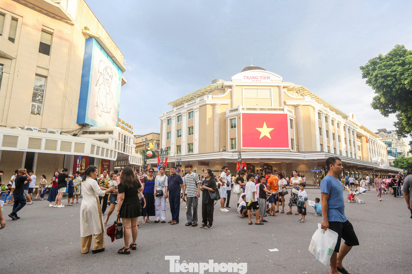 Nhiều người dân, du khách đến khu vực ngã tư Tràng Tiền - Đinh Tiên Hoàng để chụp ảnh với cờ đỏ sao vàng.