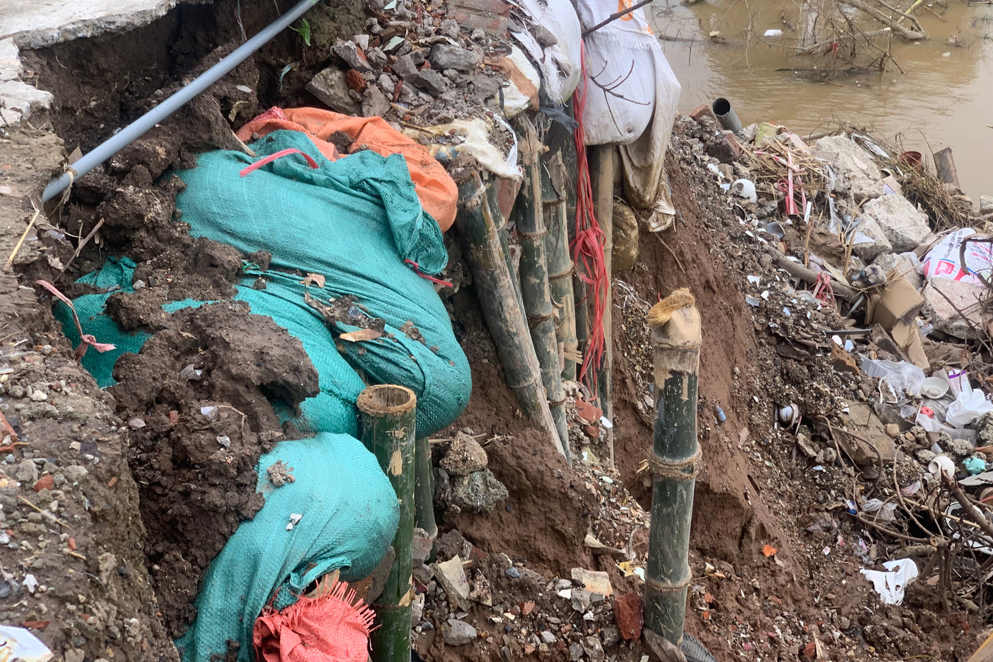 Người dân xã Kim Lan dùng cọc tre, bao cát tạm thời ngăn tình trạng sạt lở, xói mòn đất.