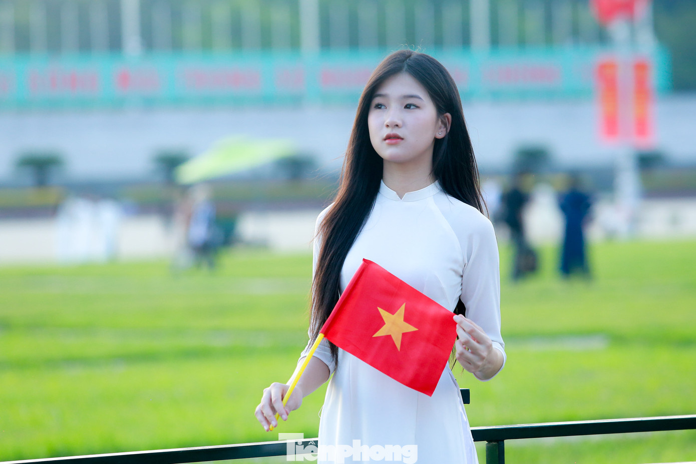 Thiếu nữ xúng xính trong bộ áo dài cùng cờ đỏ sao vàng chụp ảnh trước Quảng trường Ba Đình.
