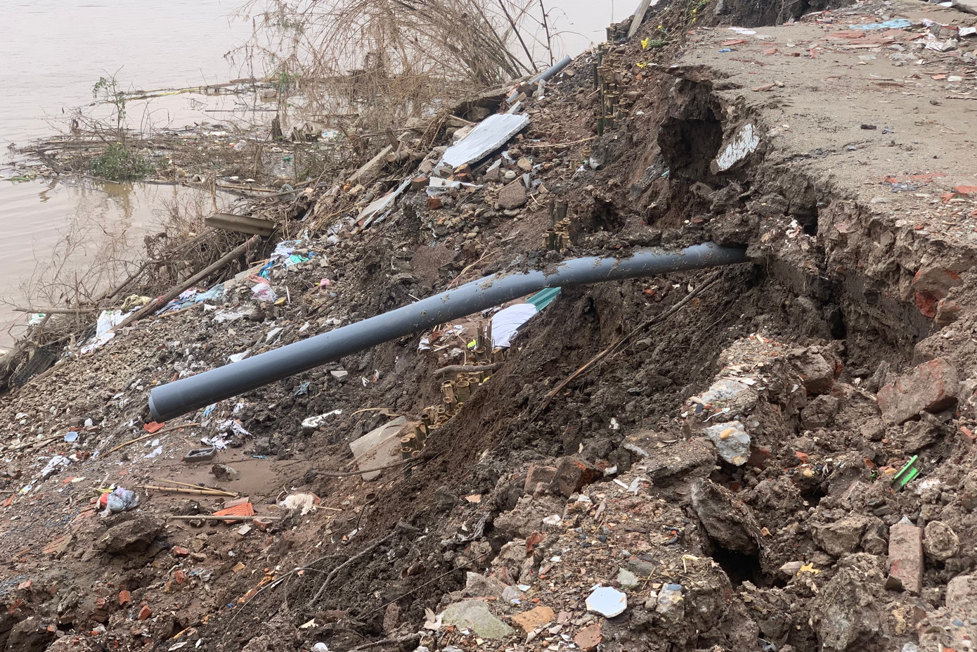 Ống nước ngầm lộ ra sau vụ sạt lở.