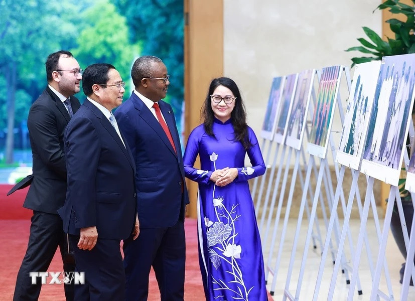 Thủ tướng Phạm Minh Chính và Tổng thống Cộng hòa Guinea-Bissau Umaro Sissoco Embaló xem trưng bày ảnh về quan hệ hợp tác giữa hai nước do TTXVN thực hiện. (Ảnh: Dương Giang/TTXVN)