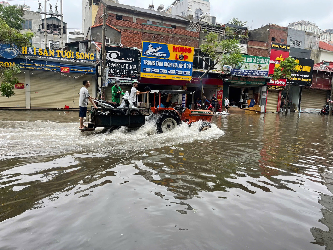 Dùng xe công nông vận chuyển xe máy qua khu vực ngập nước sâu.