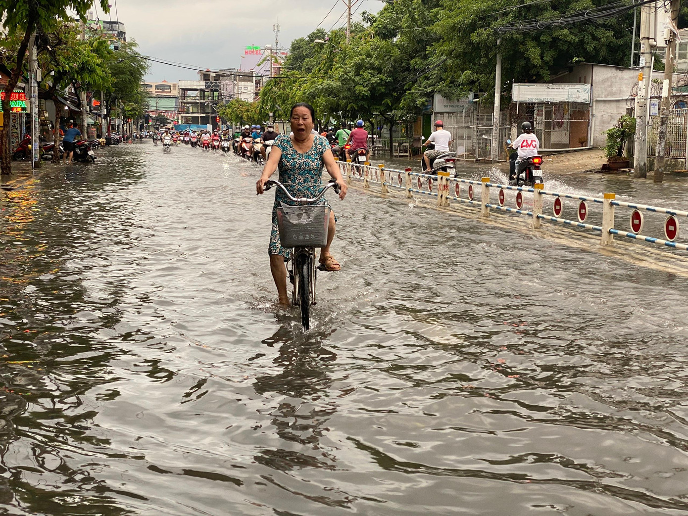 Người dân bì bõm trên đường sau cơn mưa lớn chiều 19/6.
