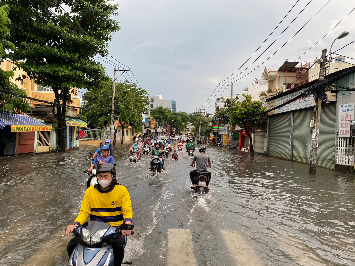Nước ngập sau mưa khiến việc kinh doanh của nhiều hộ dân trên đường gặp khó khăn.
