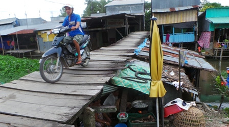  Tuy cầu gỗ đã mục nhưng hàng ngày có hàng trăm bận xe máy qua lại cầu