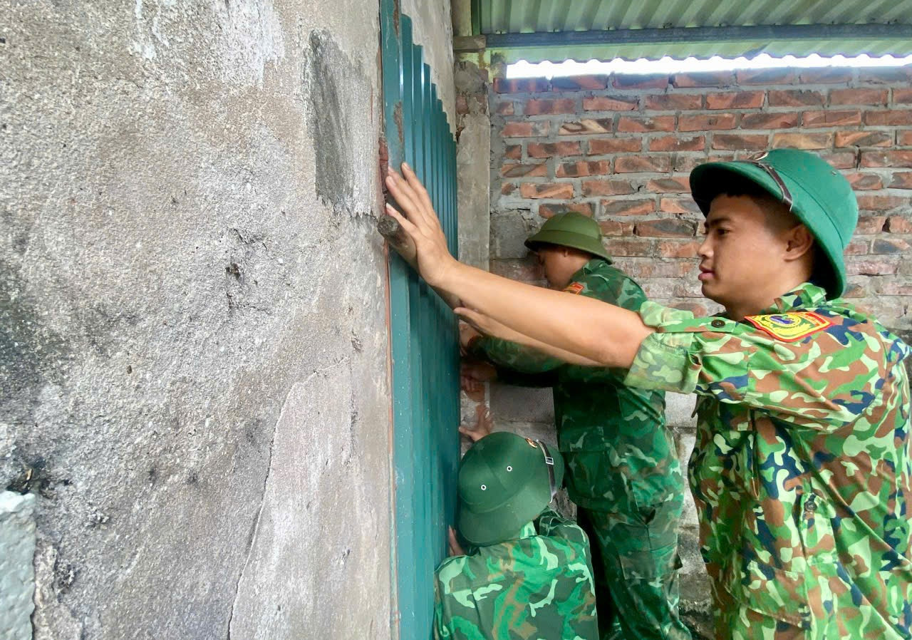 Cán bộ, chiến sĩ BĐBP đồn Cửa Lân hỗ trợ chằng, chống nhà cửa cho hộ bà Nguyễn Thị Thắm, thôn Hoàng Môn, xã Nam Cường, 70 tuổi, neo đơn.