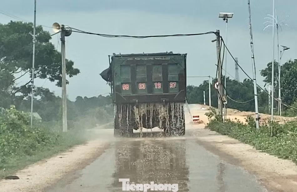 Xe tải di chuyển từ bãi tập kết cát chảy nước xuống đường.