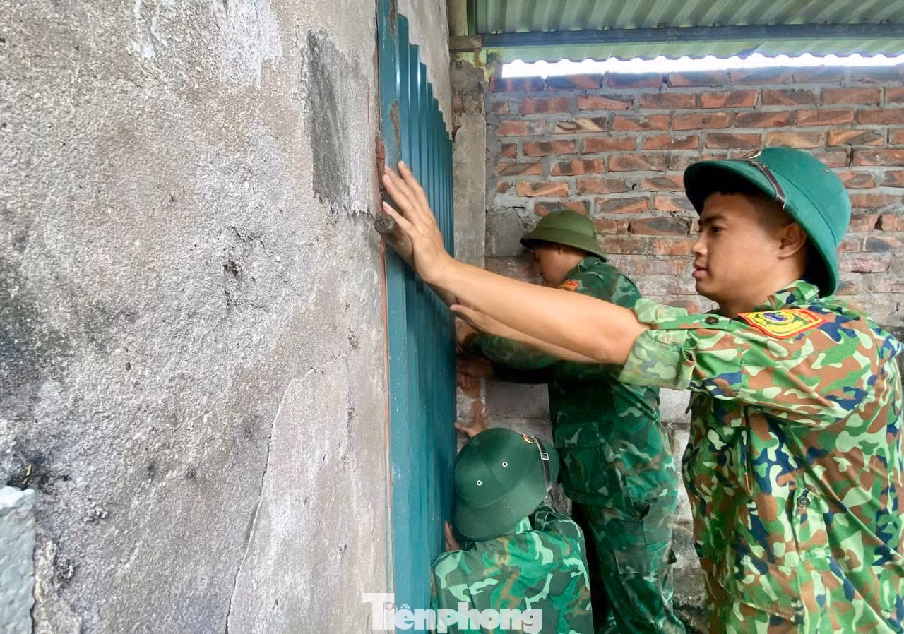 Cán bộ, chiến sỹ BĐBP đồn Cửa Lân hỗ trợ chằng, chống nhà cửa cho hộ bà Nguyễn Thị Thắm, thôn Hoàng Môn, xã Nam Cường, 70 tuổi, neo đơn.