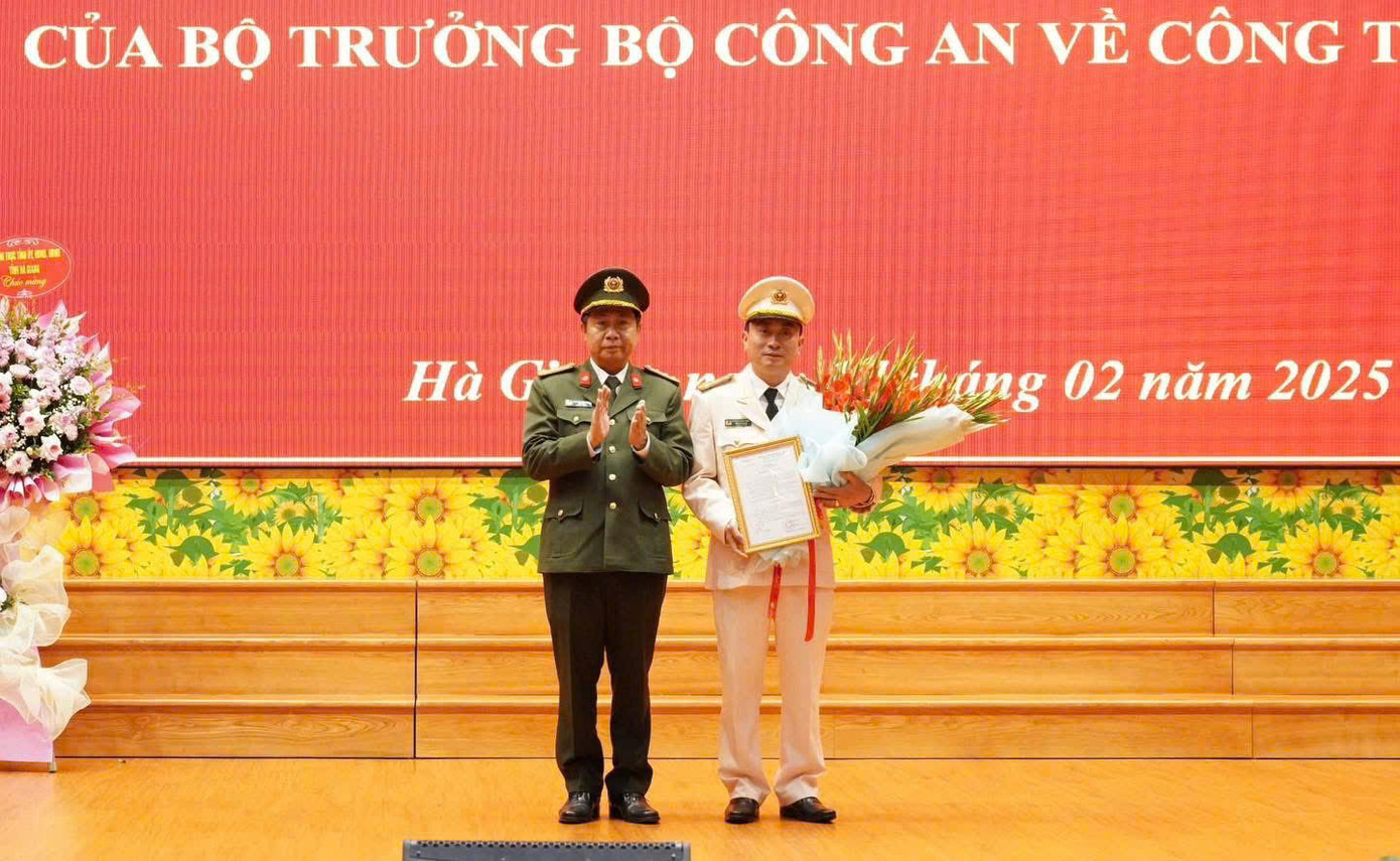 Giám đốc Công an tỉnh Hà Giang Nguyễn Đức Thuận trao quyết định và tặng hoa chúc mừng thượng tá Nguyễn Mạnh Hùng. Ảnh: Công an tỉnh Hà Giang