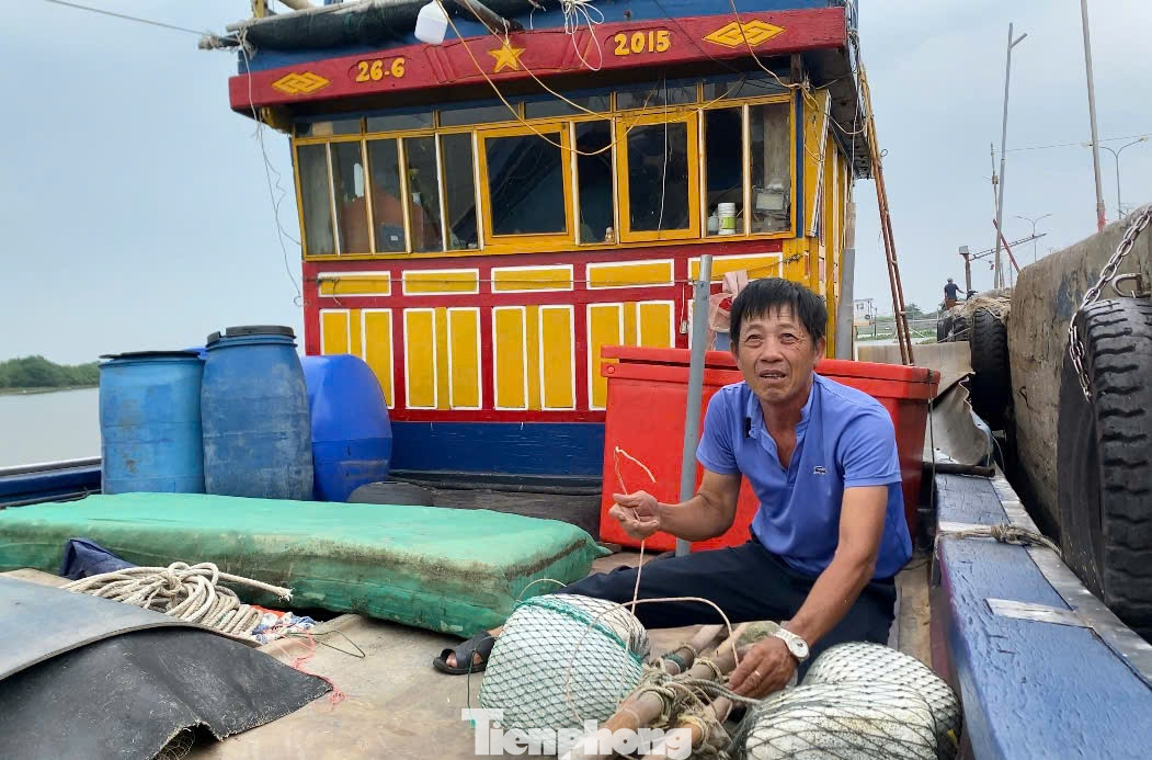 Ông Đặng Đức Hồng thực hiện các công đoạn chằng buộc tàu để chờ nước lên đưa tàu vào neo sâu trong cảng.